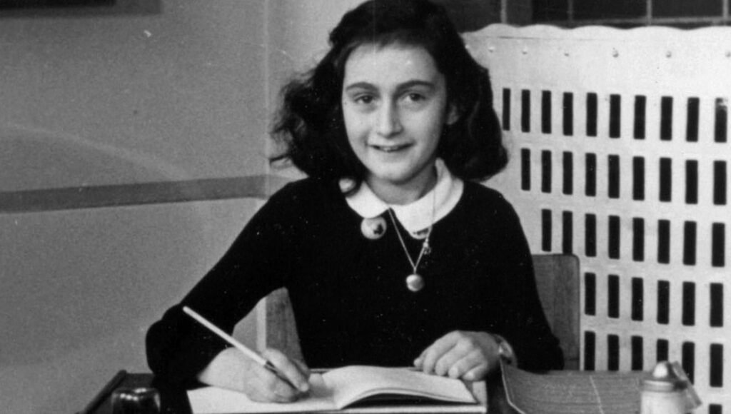 Grupo com bandeiras nazistas marcha no lado de fora de peça sobre Anne Frank